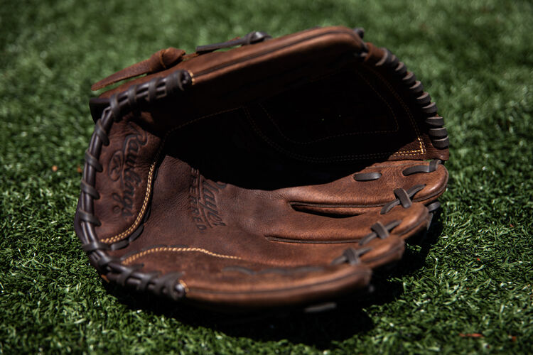 A brown palm of a Player Preferred softball glove lying on a field - SKU: P120BFL