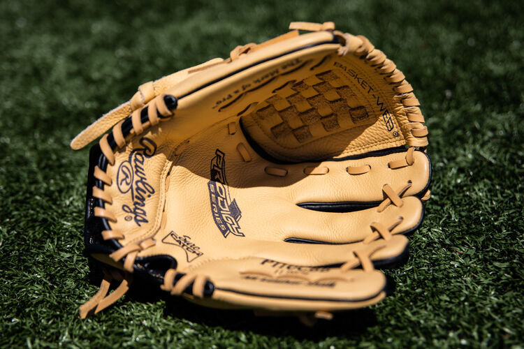 Camel palm of a Prodigy Basket Web glove lying on a field - SKU: P110CBB