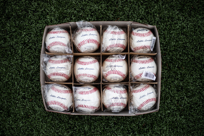 A box of a dozen Rawlings Little League balls lying on a field - SKU: RLLB1
