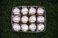A box of a dozen Rawlings Little League balls lying on a field - SKU: RLLB1 image number null