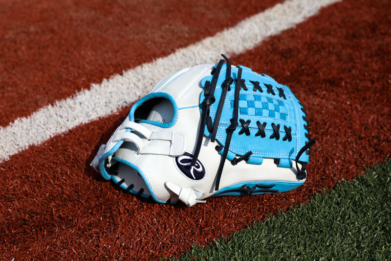 Thumb view of A Liberty Advanced Color Series fastpitch glove with a Columbia blue web and navy laces on a field - SKU: RLA125-18WCBN
