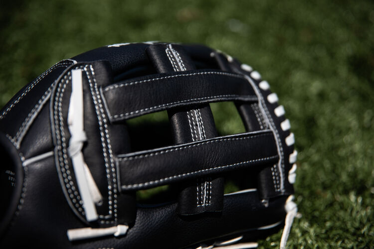 A black H-web on a Rawlings RSB softball glove with a field in the background - SKU: RSB130GBH
