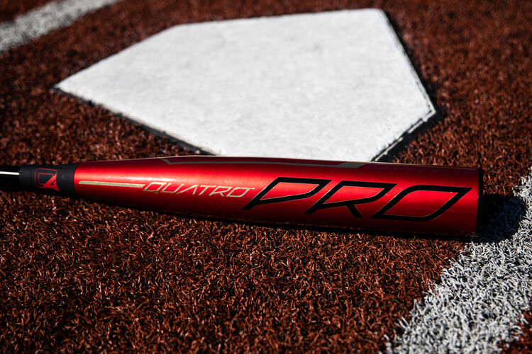 Red barrel of a Rawlings 2020 Quatro Pro baseball bat lying next to home plate - SKU: BBZQ3