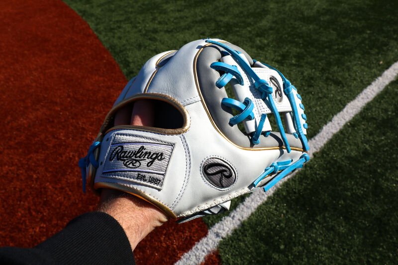 A Rawlings Heart of the Hide ColorSync 5.0 I-web infield glove on a person's hand with a field in the background - SKU: PRO314-2GW