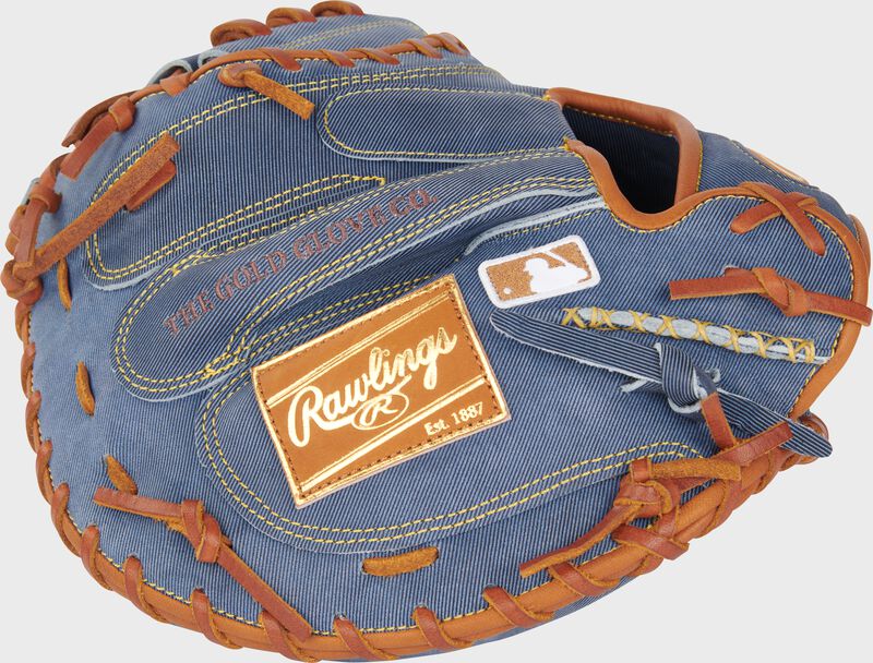Back of a Heart of the Hide Pro Label Denim catcher's mitt with a tan leather Rawlings patch and MLB logo on the pinky