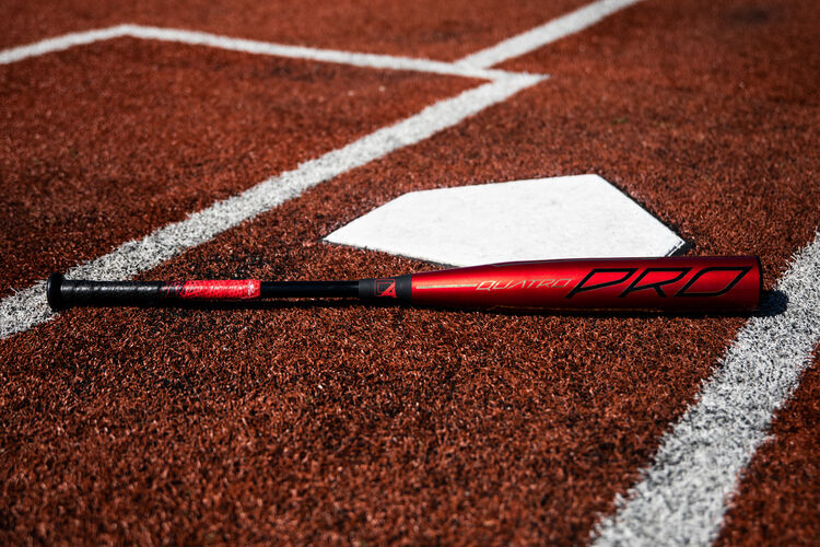 A 2020 Quatro Pro BBCOR bat lying next to home plate - SKU: BBZQ3