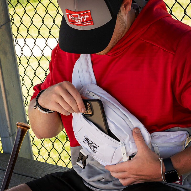 A player pulling his phone out of the front pocket of a white Players sling bag - SKU: RSLINGBG