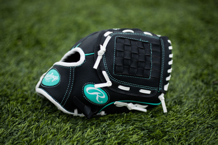 A black Players youth glove with a mint Oval-R lying on a field - SKU: PL10BMT