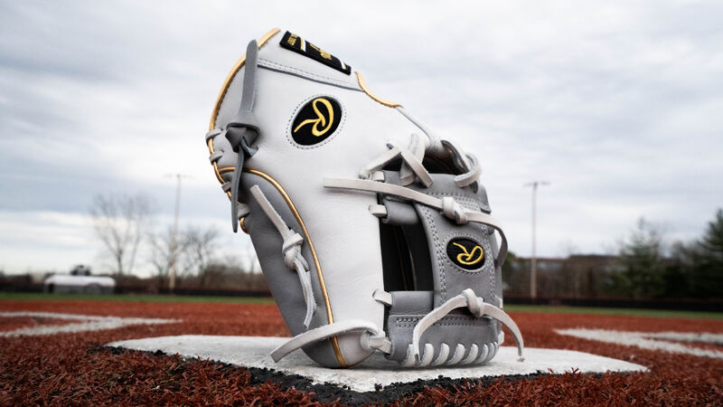 A grey/white 2020 Heart of the Hide exclusive infield glove standing up on home plate of a field - SKU: PRO204W-2GW