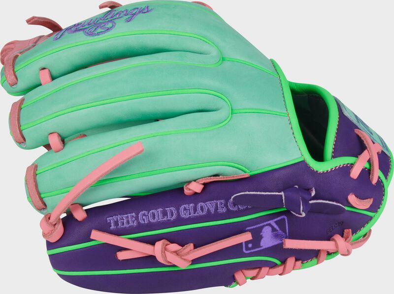 Pink/purple back of a Heart of the Hide ContoUR Fit 11.5-Inch Infield Glove with the MLB logo on the pinky