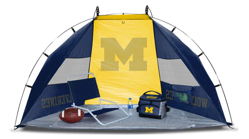A Michigan Wolverines sideline sun shelter set up with a chair, cooler, football and water bottle - SKU: 00973083111