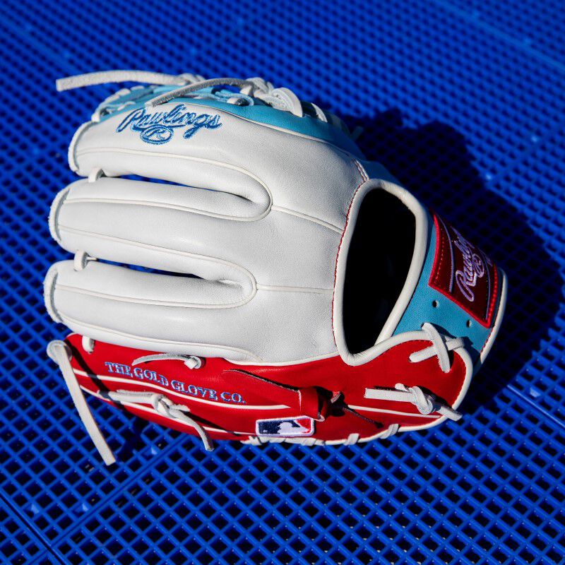 White/scarlet back of a Heart of the Hide Fro-Glo glove with a blue background