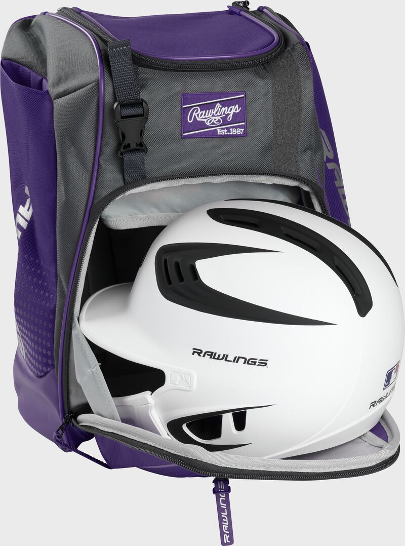 A white/black helmet in the main compartment of a purple Rawlings Franchise backpack - SKU: FRANBP-PU