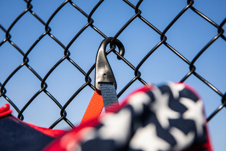 The fence hook on a USA Rawlings Legion baseball backpack hanging on a fence - SKU: LEGION-USA