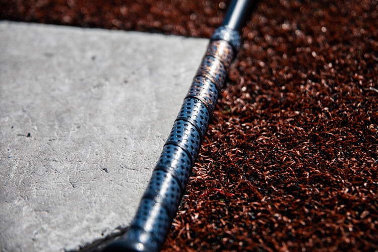Lizard Skins batting grip on a Quatro Pro fastpitch softball bat next to home plate - SKU: FPZP9