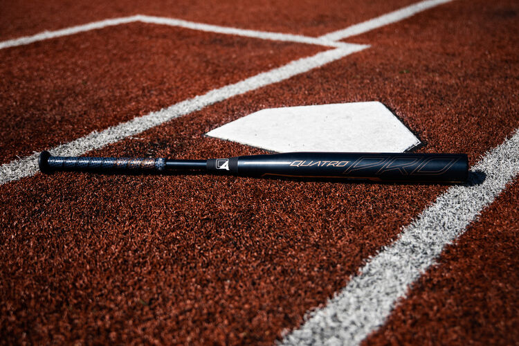A Quatro Pro -9 fastpitch bat lying on a field at home plate - SKU: FPZP9