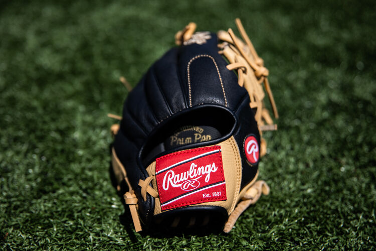 Rawlings patch on a Rawlings Prodigy glove sitting on a field- SKU: P115CBI