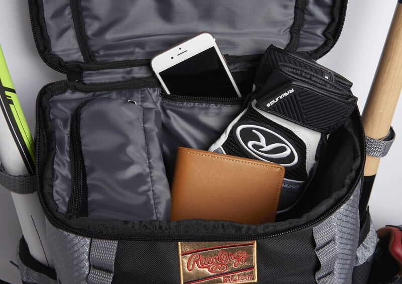 The top compartment on black/gray Gold Glove Series backpack with a wallet, phone and batting gloves