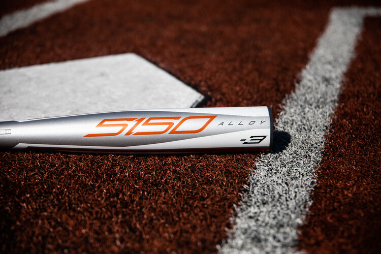 The barrel of a 2020 Rawlings 5150 baseball hat lying beside home plate - SKU: BBZ53