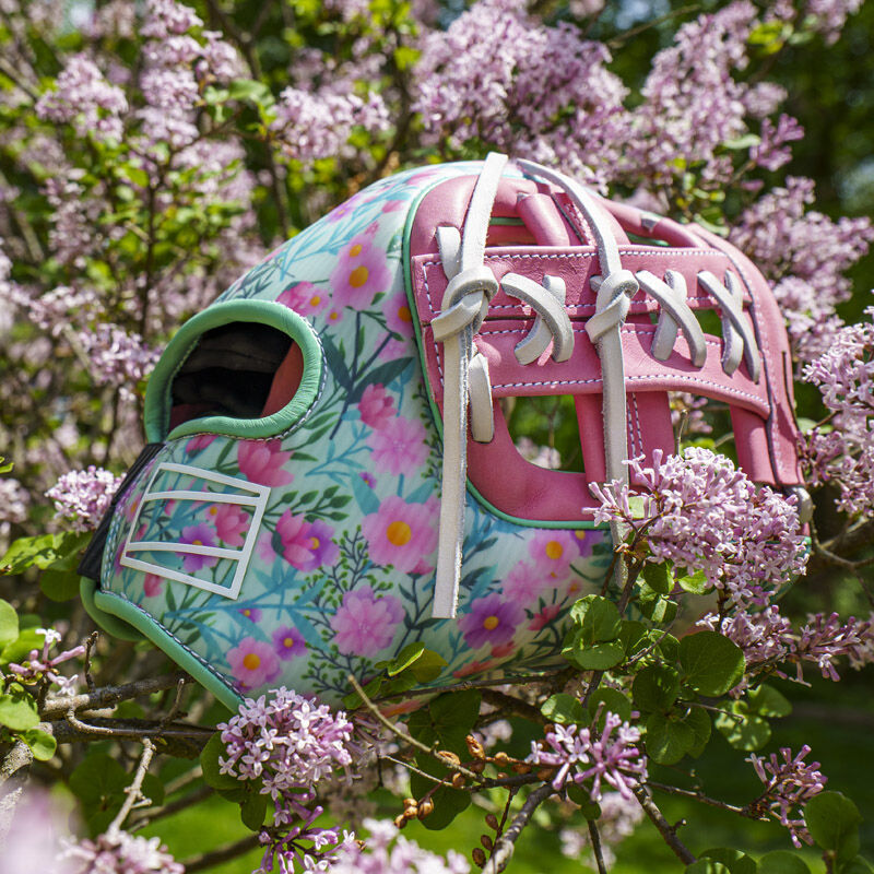 Picture of a Rawlings Mother's Day REV1X infield glove in a flower bush