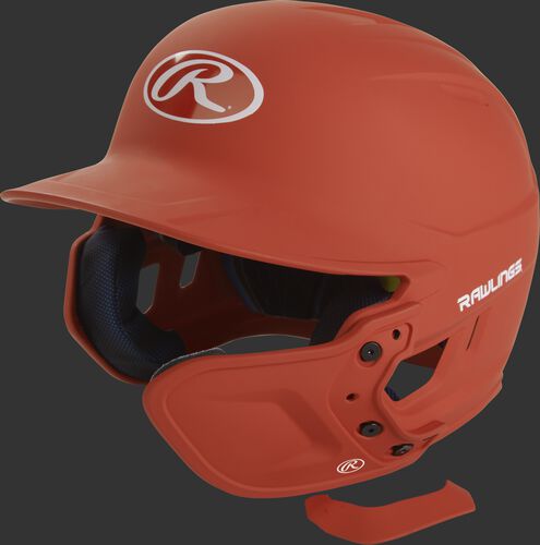 A matte burnt orange MEXT attached to a Mach batting helmet showing the hardware