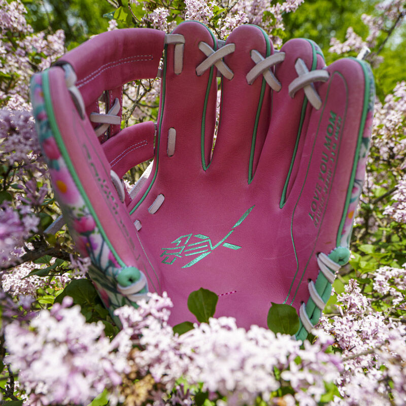 Picture of the pink leather palm of a Rawlings Race Day REV1X infield glove in a flower bush