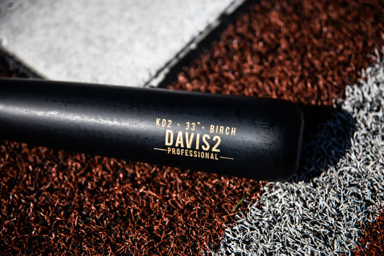 Black barrel of a Rawlings Pro Label Khris Davis bat next to home plate - SKU: KD2PL