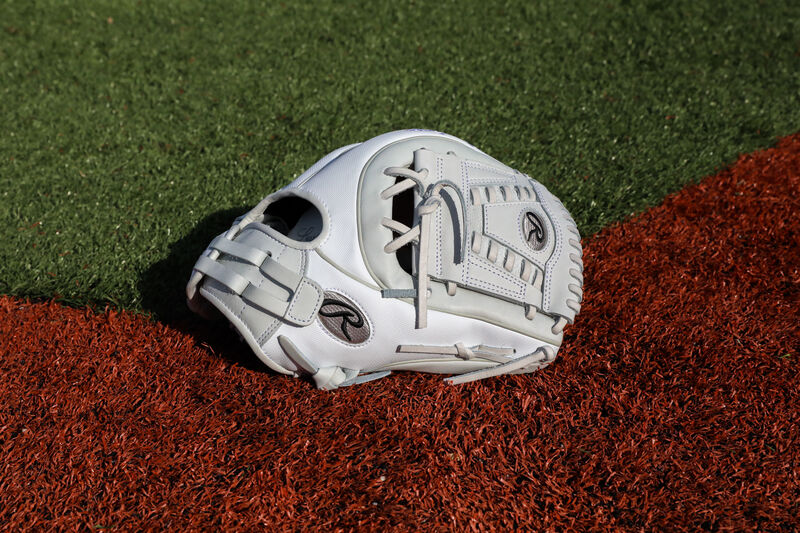 A white Liberty Advanced Color Series 11.75-Inch infield glove with white laces on a field - SKU: RLA715SB-31WSS loading=