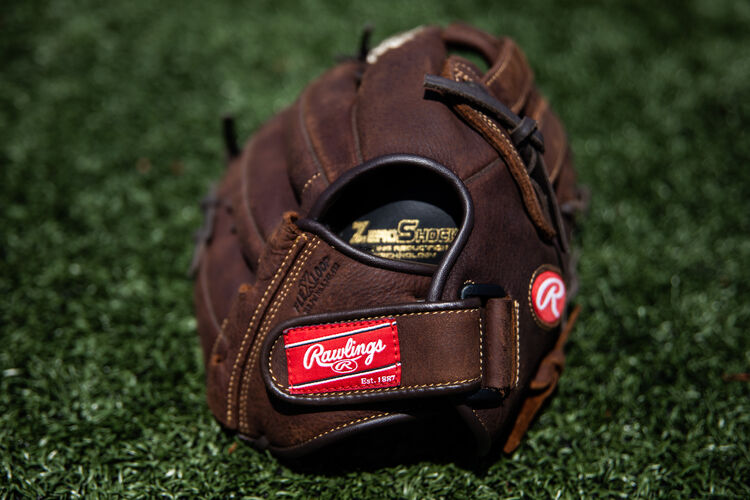 Rawlings patch on the wrist strap of a Player Preferred recreational glove on field - SKU: P130HFL