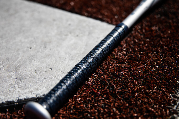 Navy blue batting grip of a Rawlings Storm fastpitch bat next to home plate - SKU: FPZS13