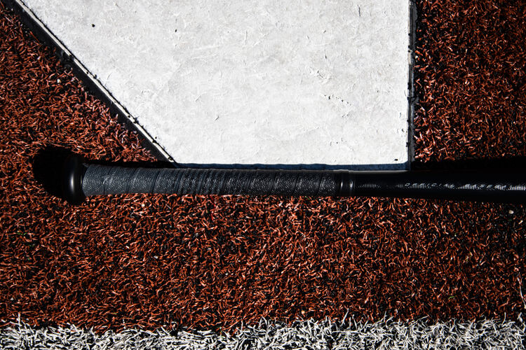Grey/black grip tape of a Rawlings Velo ACP BBCOR baseball bat lying next to home plate - SKU: BBZV3