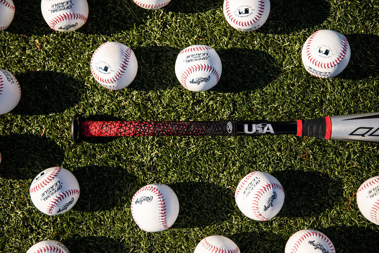 Handle of a -8 USA baseball Quatro Pro bat on a field with baseballs - SKU: US1Q8
