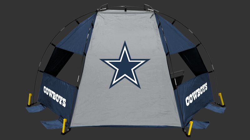 A Dallas Cowboys sun shelter set up on a beach with a chair, cooler, football and water bottle - SKU: 00961065111
