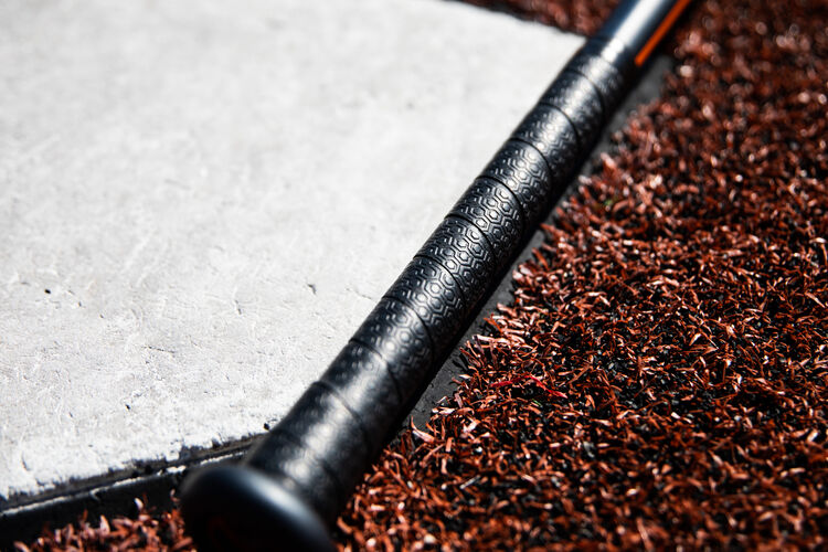 Batting grip of a 2020 Impact baseball bat next to home plate - SKU: BBZI3
