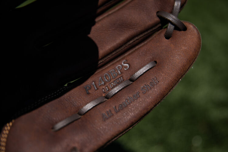 Brown pinkie of a Rawlings Player Preferred softball glove on a field - SKU: P140BPS