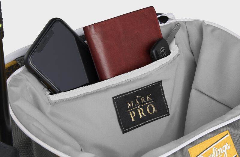 Zippered pocket in the top storage compartment of a light gold Impulse backpack with a phone, wallet and keys - SKU: IMPLSE-LG