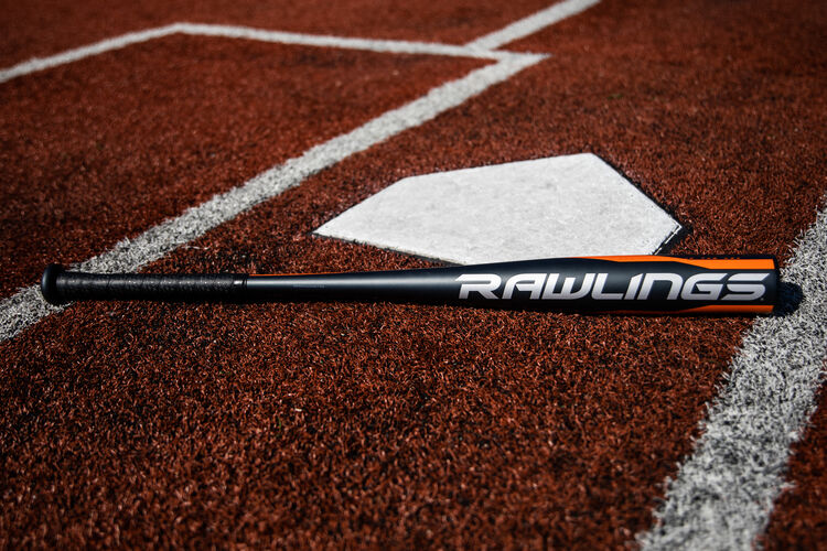 A Rawlings 2020 Impact BBCOR bat lying on a field next to home plate - SKU: BBZI3