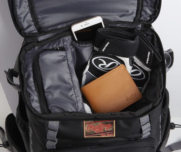 The top compartment on black Gold Glove Series backpack with a wallet, phone and batting gloves