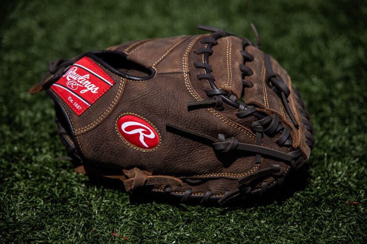 A brown Player Preferred catcher's mitt lying on a field - SKU: PCM30